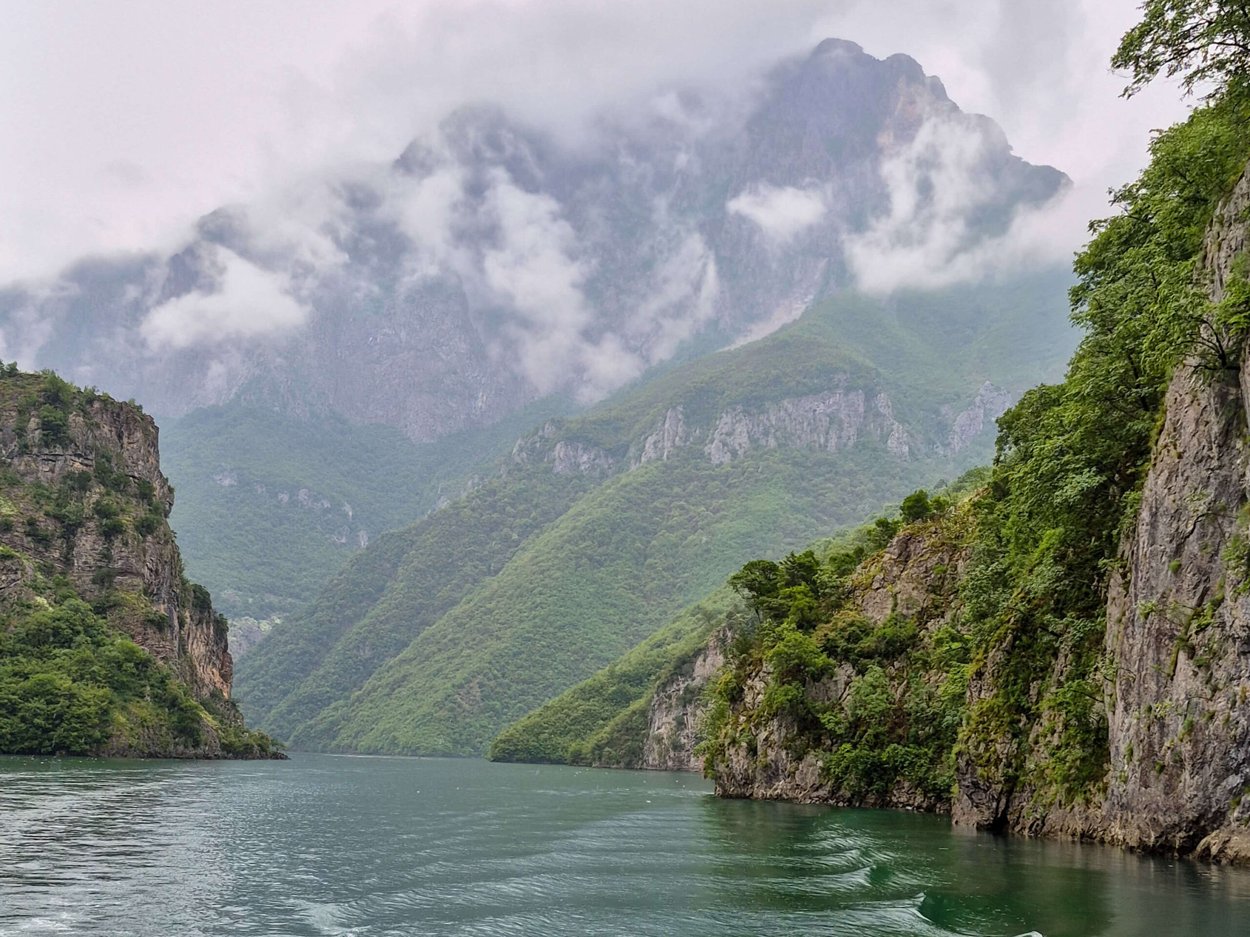Ferry die door het smalle bergmeer tussen Koman en Fierze vaart, omringd door steile kliffen